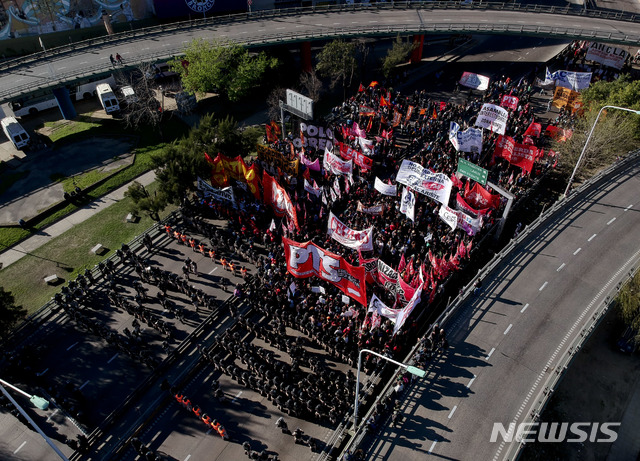 【부에노스아이레스( 아르헨티나)= AP/뉴시스】 아르헨티나 노조들의 총파업으로 25일(현지시간) 시위대가 주요 고속도로를 막고 부에노스 아이레스의 한 진출입로에서 경찰과 대치하고 있다. 