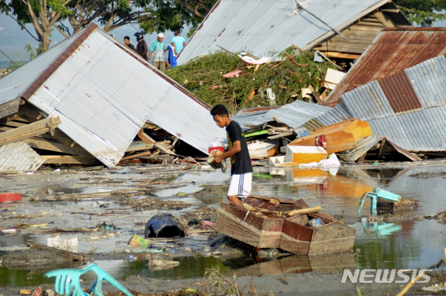 【팔루=AP/뉴시스】 인도네시아 중부 술라웨시 섬 팔루 일대에 28일 규모 7.5 지진과 쓰나미가 강타했다. 현지 주민이 29일 쓰나미에 휩쓸려간 집이 있던 주변에서 당장 사용할 가재도구를 찾고 있다. 2018.09.29 