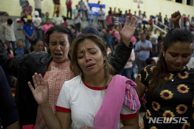Honduran migrants pray at an improvised shelter in Chiquimula, Guatemala, Tuesday, Oct. 16, 2018. U.S. President Donald Trump threatened on Tuesday to cut aid to Honduras if it doesn&#039;t stop the impromptu caravan of migrants, but it remains unclear if governments in the region can summon the political will to physically halt the determined border-crossers. (AP Photo/Moises Castillo)