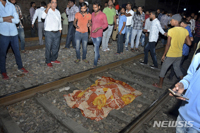 【암리차르(펀자브)=AP/뉴시스】인도 북부 펀자브 주 암리차르에서 19일(현지시간) 달리는 열차가 인파를 덮쳐 최소 50명이 사망했다. 사진은 사고 현장의 모습으로, 희생자 위에 천이 덮여있다. 이날 주민 수백명은 힌두교 축제인 두세라를 즐기다가 열차가 다가오는 것을 알아차리지 못해 사고를 당했다. 2018.10.20.