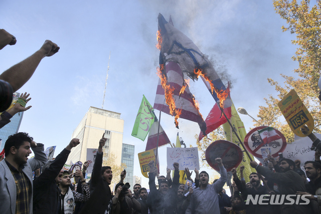 【테헤란=AP/뉴시스】이란 시민들이 지난 4일 테헤란에 위치한 이란 주재 전 미국대사관 건물 앞에서 미국과 이란의 국기를 태우며 시위를 벌이고 있다. 2018.11.5. 