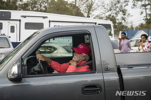 미국 조지아 주 알바니에서 한 남성이 투표소 주차 공간을 찾는 모습. 이 남성은 도널드 트럼프 미국 대통령의 구호인 '미국을 다시 위대하게'라는 문구가 적힌 빨간 모자를 쓰고 있다. 