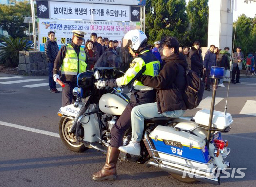 【제주=뉴시스】강정만 기자 = 수학능력시험이 치러지는 15일 제주 자치경찰이 차량정체로 수험장에 늦을 것으로 예상되는 학생을 싸이카에 태워 수험장으로 가고 있다. 2018. 11.15 (사진= 제주 자치경찰단 제공) photo@newsis.com