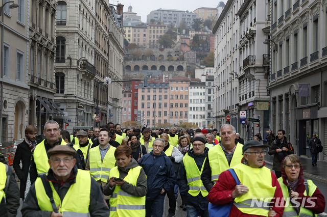 【리옹=AP/뉴시스】 17일(현지시간) 프랑스 중부 리옹에서 운전자용 노란 안전 조끼를 입고 단체 행동에 나서 일명 '노란 조끼(gilets jaunes)'라고 불리는 시위대가 유류세 인상에 항의하는 행진을 하고 있다. 2018.11.18.