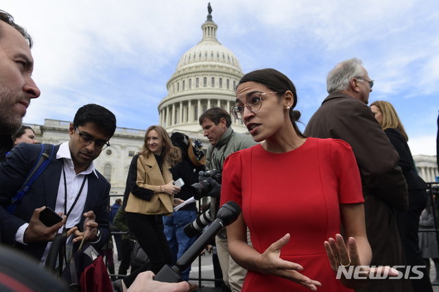 FILE - In this Nov. 14, 2018, file photo, Rep.-elect Alexandria Ocasio-Cortez, D-N.Y., talks with reporters following a photo opportunity on Capitol Hill in Washington, with the freshman class. Ocasio-Cortez seems to be everywhere. She’s cooked soup, live on Instagram. She’s done laundry in public. And she’s clapped back at critics of her clothing and a misstatement. The New York Democrat, who at 29 is the youngest woman to be elected to Congress, says she’s documenting her journey to Capitol Hill to lift some of the mystery of the place and make it, ‘real.’ (AP Photo/Susan Walsh, File)