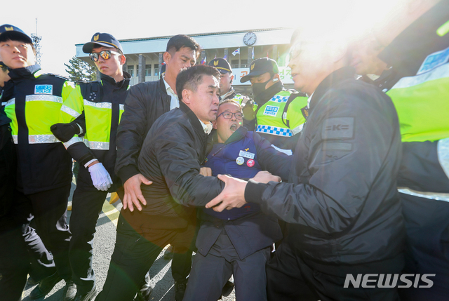 【제주=뉴시스】우장호 기자 = 제주도가 국내 첫 영리병원 개원을 허가한 5일 오후 제주도청 앞에서 내부 진입을 시도하던  제주도내 30개 노동·시민단체·정당 단체로 구성된 '의료영리화저지와 의료공공성강화를 위한 제주도민운동본부' 관계자가 경찰에 의해 저지당하고 있다. 2018.12.05. woo1223@newsis.com