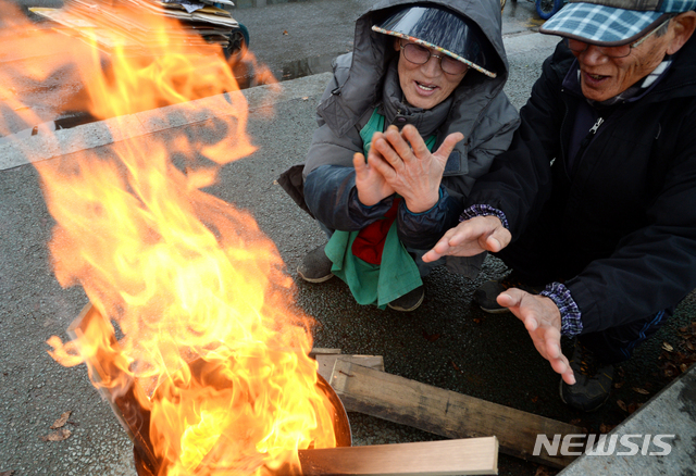 【전주=뉴시스】김얼 기자= 전북 전주시의 체감온도가 영하 1도까지 내려가는 등 강추위가 시작되면서 차가운 겨울 날씨를 보인 6일 완산구 남부시장에서 상인들이 모닥불을 쬐며 추위를 녹이고 있다. 2018.12.06pmkeul@newsis.com