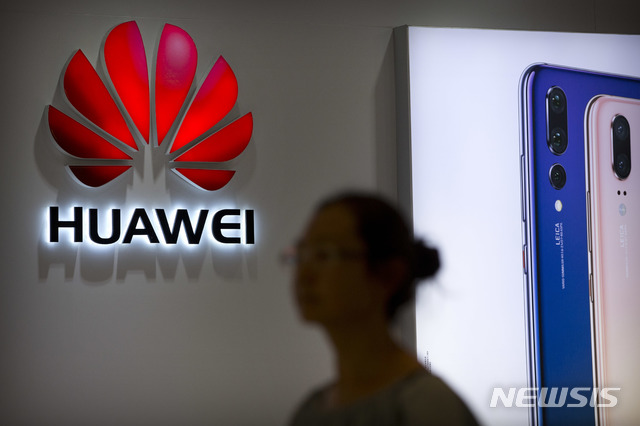 FILE - In this July 4, 2018, file photo, a shopper walks past a Huawei store at a shopping mall in Beijing. Canadian authorities said Wednesday, Dec. 5, 2018, that they have arrested the chief financial officer of China&#039;s Huawei Technologies for possible extradition to the United States. (AP Photo/Mark Schiefelbein, File)
