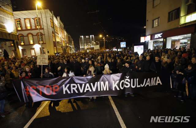 【벨그라드( 세르비아) = AP/뉴시스】세르비아 국기를 든 시위대가 지난 주말 벨그라드 시내를 행진하고 있다. 이들은 야당 당수에 대한 기습 폭행에 항의하면서 "피묻은 셔츠는 이제 그만"이라고 쓴 펼침막을 들고 시위에 나섰다.  