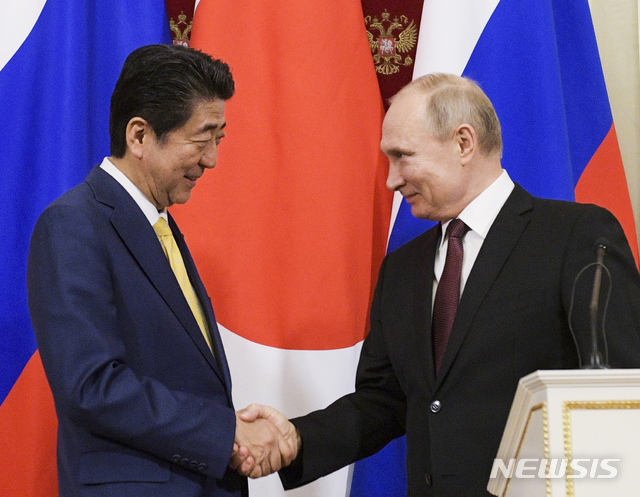 【모스크바=AP/뉴시스】 블라디미르 푸틴 러시아 대통령(오른쪽)과 아베 신조 일본 총리가 22일(현지시간) 모스크바 크렘린궁에서 열린 공동기자회견에서 악수를 나누고 있다. 2019.1.23