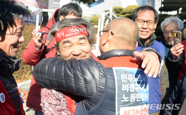 【전주=뉴시스】김얼 기자= 택시 사납금제도의 철폐와 택시전액관리제 도입 등을 주장하며 2017년 9월 4일 고공농성을 시작한 김재주 민주노총 택시노조 전북지회장이 고공농성 510일만인 2019년 1월 26일 전액관리제 협상이 타결된 소식을 듣고 고공농성장에서 내려와 노조원들과 포옹을 나누고 있다. 2019.01.26.pmkeul@newsis.com