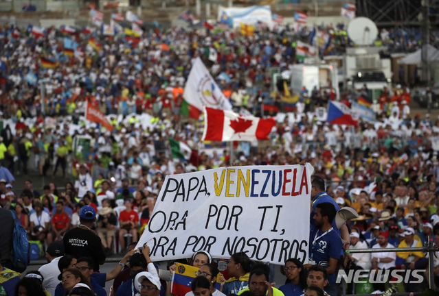 【파나마시티=AP/뉴시스】26일(현지시간) 파나마 수도 파나마시티의 성 요한 바오로 2세 광장에서 열린 세계 청년의 날(WYD) 철야 기도회에 참가한 베네수엘라 참가자들이 플래카드를 들고 프란치스코 교황을 맞고 있다. 플래카드에는 "베네수엘라는 교황님을 위해 기도합니다. 교황님도 우리를 위해 기도해 주세요"라고 쓰여 있다. 2019.01.27.
