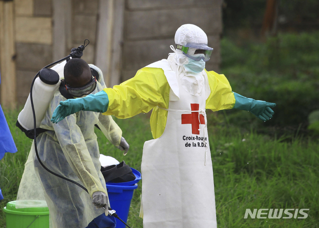 【베니(콩고)= AP/뉴시스】 지난 해 9월 에볼라가 발생한 콩고 베니 일대에서 보건부 직원들이 감염을 막기 위해 의료진의 몸에 소독약을 뿌리고 있다.