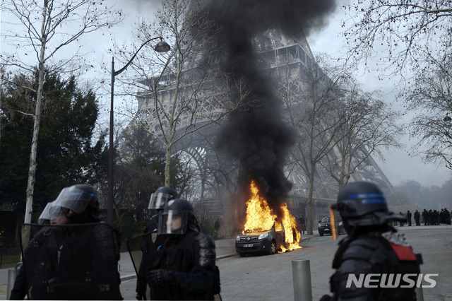 【파리=AP/뉴시스】 프랑스 수도 파리에서 9일(현지시간) '노란조끼'가 주도하는 반정시위가 13주일째 펼쳐졌다. 에펠탑 부근에서 폭도로 변한 일부 시위대가 방화한 대테러용 군지휘차량이 검은 연기를 뿜어내면서 불타고 있다. 2019.02.10 