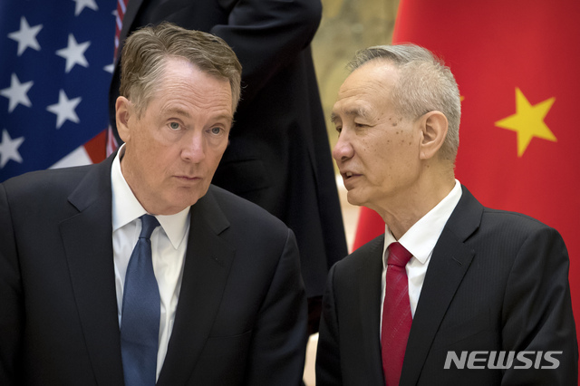 FILE - In this Feb. 15, 2019, file photo, Chinese Vice Premier Liu He, right, talks with U.S. Trade Representative Robert Lighthizer, while they line up for a group photo at the Diaoyutai State Guesthouse in Beijing. China&#039;s economy czar is going to Washington for talks Thursday and Friday aimed at ending a tariff war over Beijing&#039;s technology ambitions.(AP Photo/Mark Schiefelbein, File)