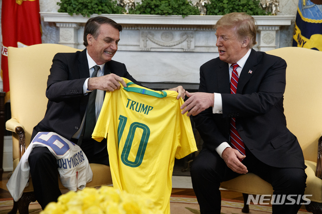 [워싱턴=AP/뉴시스]자이르 보우소나루(왼쪽) 브라질 대통령이 2019년 3월 19일(현지시간) 백악관에서 도널드 트럼프 대통령과 정상회담에 앞서 인사를 나누는 모습.
