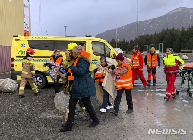【후스타드비카( 노르웨이)= AP/뉴시스】 노르웨이 크루즈선박 바이킹 스카이호의 승객들이 23일(현지시간) 혹한과 강풍속에서 헬기로 구조되어 후스타드비카 부두의 구조대원들의 도움으로 대피소로 이동하고 있다.  