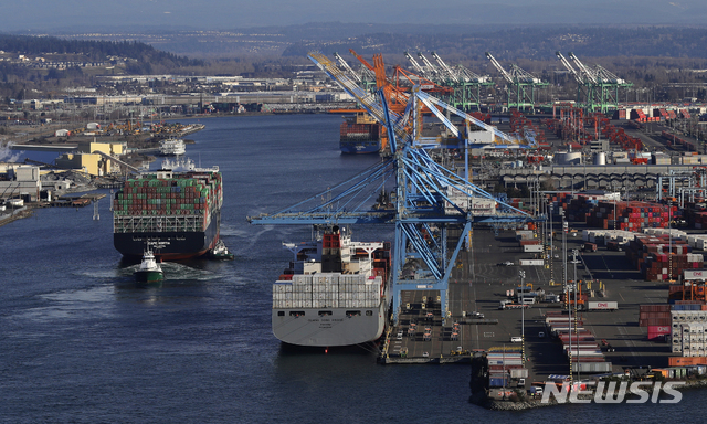 FILE- In this Tuesday, March 5, 2019, file photo the Cape Kortia container ship, left, heads into the Port of Tacoma in Commencement Bay in Tacoma, Wash. On Thursday, March 28, the Commerce Department issues the final estimate of how the U.S. economy performed in the October-December quarter. (AP Photo/Ted S. Warren, File)