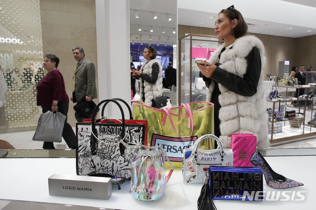 FILE- In this March 14, 2019, file photo a woman shops at Neiman Marcus during the opening night of The Shops & Restaurants at Hudson Yards in New York. On Friday, March 29, the Commerce Department issues its January report on consumer spending, which accounts for roughly 70 percent of U.S. economic activity. (AP Photo/Mark Lennihan, File)