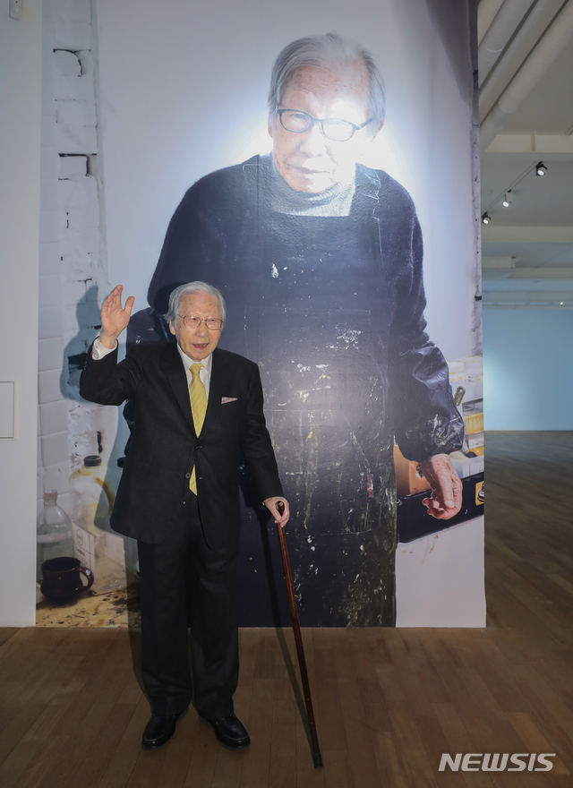 【서울=뉴시스】조수정 기자 = 국내 최고령 화백인 김병기 작가가 만 103세 생일을 맞은 10일 오전 서울 평창동 가나아트센터에서 개인전 '여기, 지금(Here and Now)' 개막 기자간담회를 열고 작업실에서 촬영한 사진 앞에서 포즈를 취하고 있다. 2019.04.10. chocrystal@newsis.com