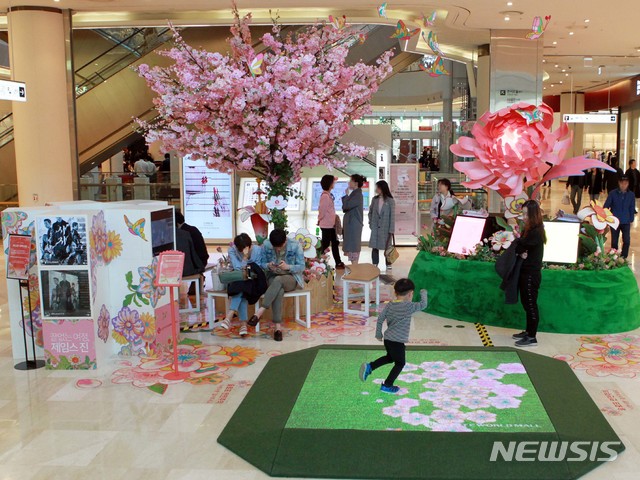 【서울=뉴시스】롯데월드몰 1층 인터랙티브 미디어. 고객 움직임에 따라 제임스 진의 벚꽃과 나비 이미지가 펼쳐진다. 