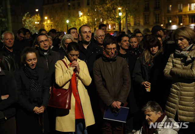 【파리=AP/뉴시스】 15일(현지시간) 프랑스 파리 노트르담 대성당에 불이 났다. 지켜보는 시민들이 기도하고 있다.