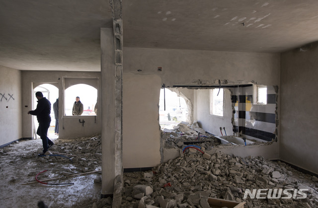이스라엘군이 파괴한 아파트 내부를 팔 인들이 뒤에 살펴보고 있다  AP