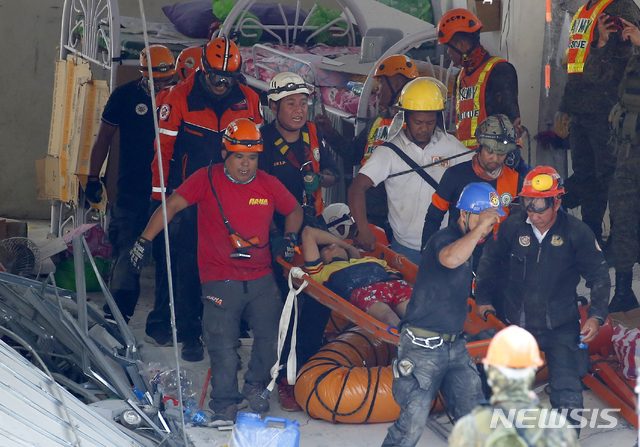 【포라크=AP/뉴시스】 필리핀 팜팡가 주 포라크에서 23일 구호요원들이 전날 발생한 규모 6.1의 지진으로 무너진 건물 잔해더미에서 생존자들을 구해 옮기고 있다. 2019.04.23 