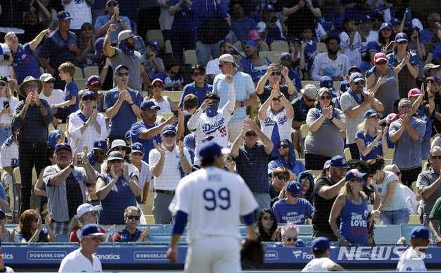 The crowd cheers for Los Angeles Dodgers starting pitcher Hyun-Jin Ryu (99) as he walks off the field during the eighth inning of a baseball game against the Washington Nationals, Sunday, May 12, 2019, in Los Angeles. (AP Photo/Marcio Jose Sanchez)