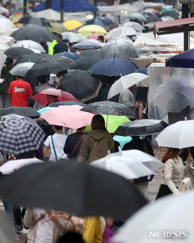 【서울=뉴시스】추상철 기자 = 더위를 시켜준 비가 내린 19일 오후 서울 중구 명동거리에는 우산을 쓴 관광객으로 붐비고 있다. 2019.05.19. scchoo@newsis.com