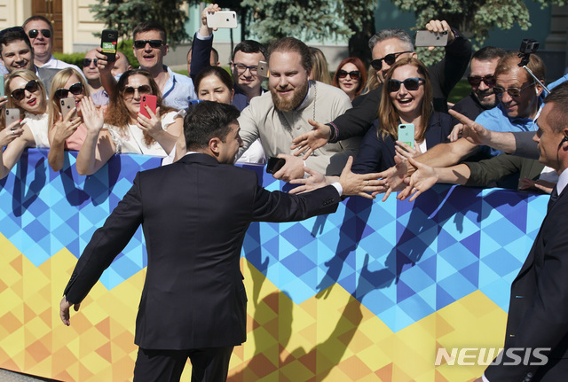【키예프(우크라이나)=AP/뉴시스】볼로디미르 젤렌스키 새 우크라이나 대통령이 20일 취임식을 위해 키예프의 의회로 걸어가며 거리에 나온 군중들과 악수하고 있다. 젤렌스키 대통령은 이날 취임 직후 우크라이나 의회를 해산한다고 선포했다. 2019.5.20