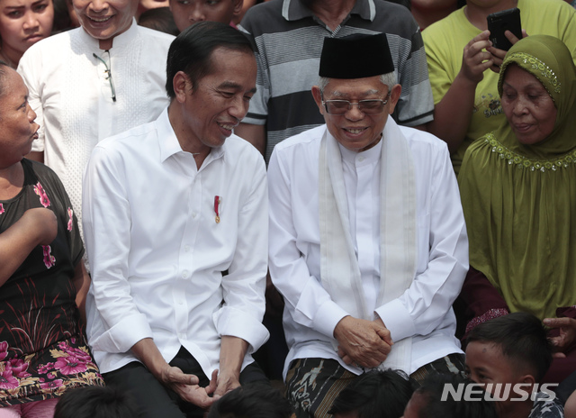 【자카르타=AP/뉴시스】조코 위도도 인도네시아 대통령(왼쪽)과 마루프 아민 부통령 당선자가 지난 5월21일(현지시간) 인도네시아 자카르타의 한 빈민가에서 자신들의 승리 선언에 앞서 얘기를 나누고 있다. 2019.08.16