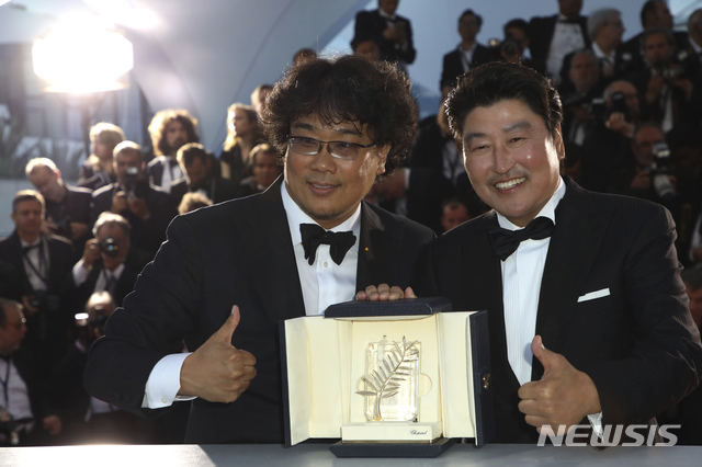 Actor Kang-Ho Song, right, and director Bong Joon-ho pose with the Palme d'Or award for the film 'Parasite' during a photo call following the awards ceremony at the 72nd international film festival, Cannes, southern France, Saturday, May 25, 2019. (Photo by Vianney Le Caer/Invision/AP) 