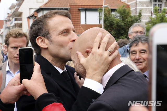 【르투케=AP/뉴시스】 에마뉘엘 마크롱(왼쪽) 프랑스 대통령이 26일(현지시간) 유럽의회 투표를 마친 뒤 지지자의 이마에 입을 맞추고 있다. 2019.05.27.