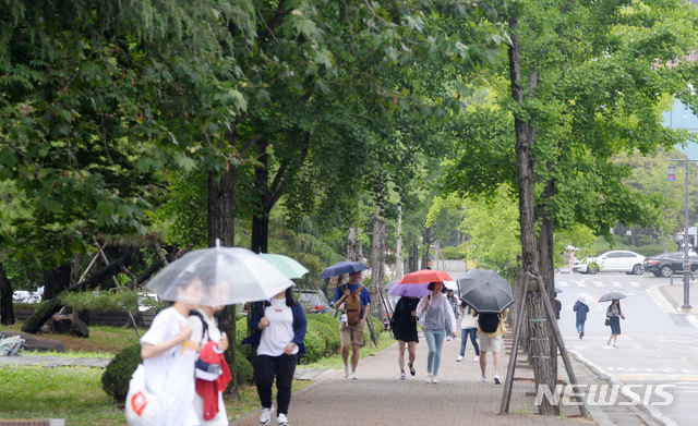 【전주=뉴시스】 김얼 기자= 전북대학교에서 학생들이 우산으로 비를 피하며 교정을 지나고 있다. 