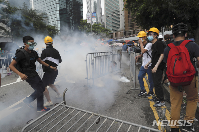 【홍콩=AP/뉴시스】홍콩 입법원 근처에서 12일 범죄인 인도법 반대 시위참가자들이 경찰이 쏜 최루가스를 피하고 있다. 2019.06.12 