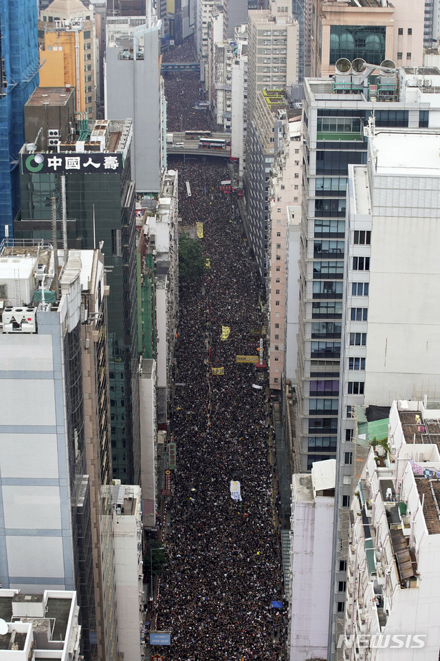 【홍콩=AP/뉴시스】홍콩에서 범죄인 인도법 철회를 요구하는 항의 시위가 연일 계속되고 있는 가운데 200만명이 넘는 홍콩 시민들이 16일 홍콩 시내에서 거리 행진을 벌이고 있다. 2019.06.16