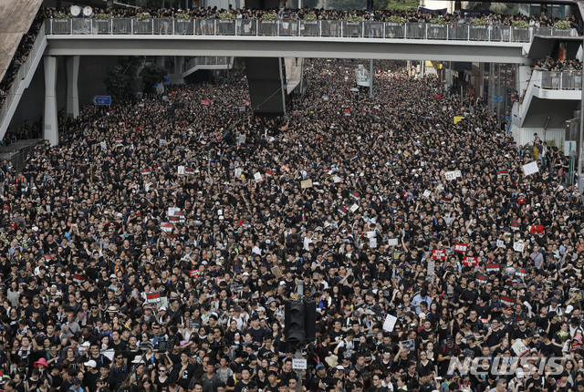 【홍콩=AP/뉴시스】홍콩에서 범죄인 인도법 철회를 요구하는 항의 시위가 연일 계속되고 있는 가운데 200만명이 넘는 홍콩 시민들이 16일 홍콩 시내에서 거리 행진을 벌이고 있다. 2019.06.16