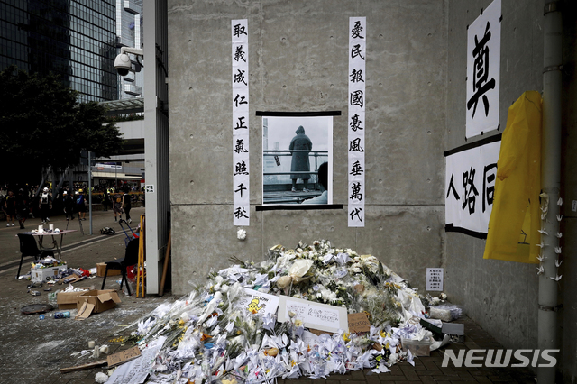 【홍콩=AP/뉴시스】 범죄인 인도법 반대 시위를 벌이다 사망한 남성을 추모하는 꽃다발들이 17일 홍콩 시내의 도로 한 켠에 쌓여있다. 이 남성은 지난 15일 고층건물에서 시위를 벌이다 떨어져 사망했다. 2019.06.17