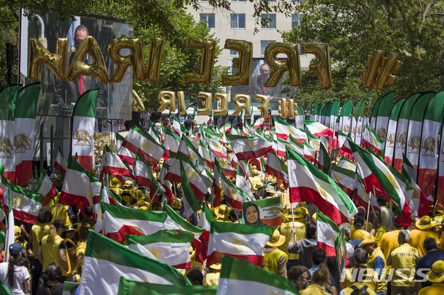 【워싱턴=AP/뉴시스】21일(현지시간) 미 워싱턴 국무부 앞에 이란의 정권 교체를 촉구하는 시위대가 이란 국기와 이란 반정부단체 ‘인민무자헤딘'(MEK) 지도자 마리암 라자비의 사진을 들고 백악관으로의 행진을 준비하고 있다. 2019.06.22. 