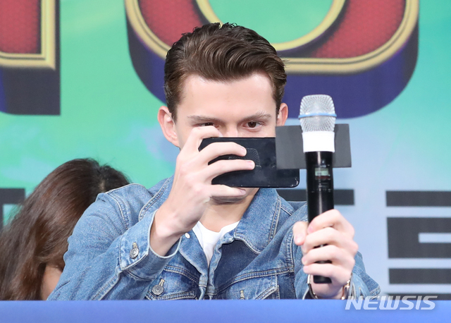 【서울=뉴시스】조수정 기자 = 배우 톰 홀랜드(Tom Holland. 왼쪽)가 영화 '스파이더맨 : 파 프롬 홈' 내한 기자간담회가 열린 1일 오전 서울 종로구 포시즌스호텔에서 취재진에게 플래시를 터트려달라고 요청한 뒤 휴대전화기로 사진을 찍고 있다. 영화 '스파이더맨 : 파 프롬 홈'은 2일 개봉한다. 2019.07.01. chocrystal@newsis.com