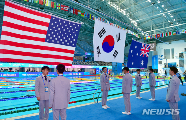 【광주=뉴시스】류형근 기자 = '평화의 물결 속으로(DIVE INTO PEACE)' 2019광주FINA세계수영선수권대회 개막을 이틀 앞둔 10일 오후 광주 광산구 남부대국제수영장에서 시상요원들이 국기게양 연습을 하고 있다. 2019.07.10  hgryu77@newsis.com