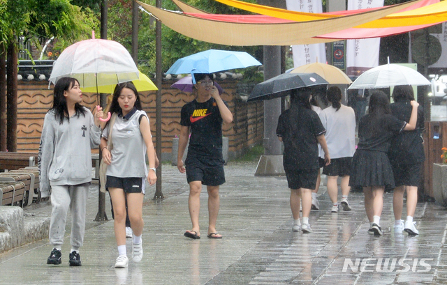 전북 전주한옥마을을 찾은 관광객들이 우산을 들고 걸음을 재촉하고 있다. 2019.07.10.pmkeul@newsis.com
