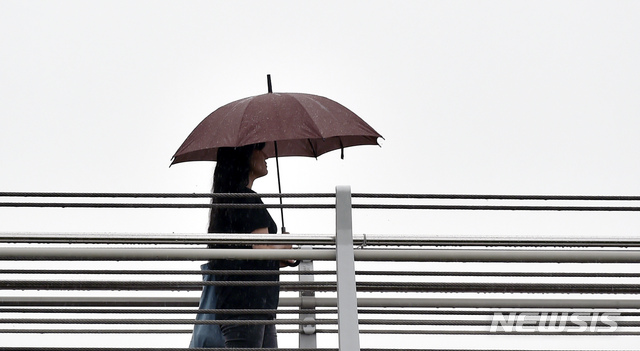【경산=뉴시스】우종록 기자 = 장맛비가 내리고 있는 10일 오후 경북 경산시 중방동 남천 보도교에서 한 시민이 우산을 쓰고 비를 피해 발걸음을 재촉하고 있다. 2019.07.10.wjr@newsis.com