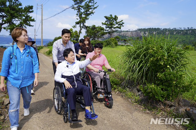 【제주=뉴시스】원희룡 제주지사는 12일 오전 제주도의 주요 관광지인 제주올레 8코스와 서귀포 치유의 숲을 잇따라 방문, 관광약자를 위한 시설을 둘러봤다. 원 지사는 지난 5월 초 공식 행사 중 다리부상으로 휠체어를 타고 다니고 있다.(사진= 제주도청 제공) 