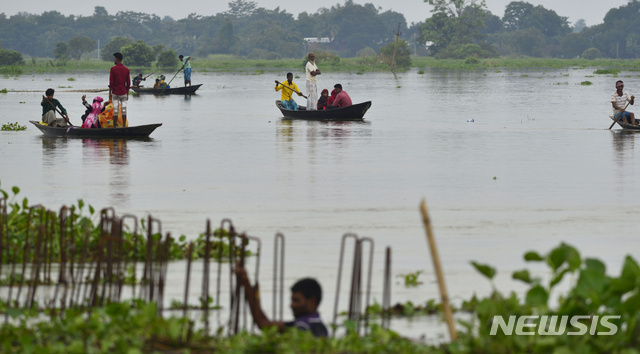 13일 인도 아삼주에서 홍수로 사람들이 보트로 이동하고 있다  AP 