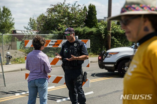 【AP/뉴시스】 타코마 이민수용소 앞길을 차단한 경찰이 이민정책 반대시위에 참가하려는 일반인들을 돌려보내고 있다. 