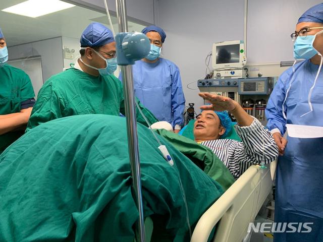 【중산=AP/뉴시스】중국내 행사도중 습격 당한 홍콩 배우 런다화(任達華·임달화)가 20일 홍콩으로 옮겨져 2차 수술을 받았다. 중국 광둥성 중산시 병원에서 런씨가 의료진과 대화를 나누고 있다. 2019.07.21 