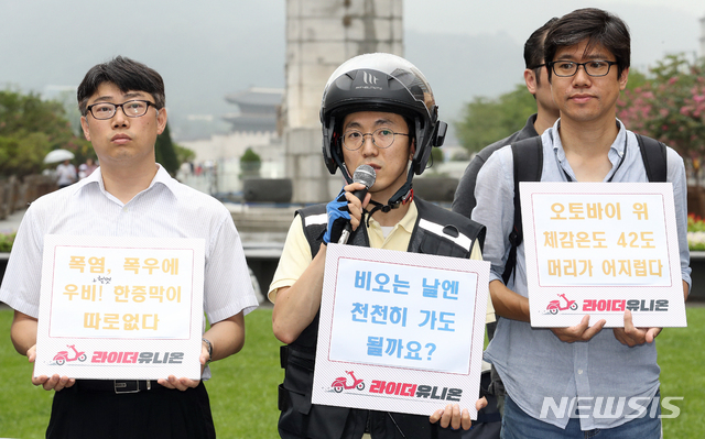 【서울=뉴시스】김병문 기자 = 박정훈(가운데) 라이더유니온 위원장이 25일 오후 서울 종로구 광화문광장에서 열린 '폭염에 폭우까지. 라이더가 위험하다' 기자회견에 참석해 헬멧을 착용한 채 발언하고 있다. 2019.07.25. dadazon@newsis.com