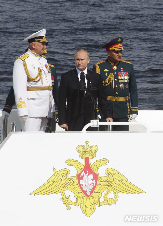 푸틴 대통령이 세르게이 쇼이구 국방장관(오른쪽) 및 니콜라이 예브메노프 해군 총사령관과 함께 해군퍼레이드를 주재하고 있다  AP  